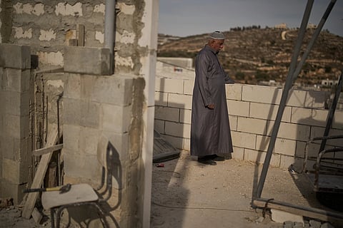 Mahmoud Tubasi stands on a rooftop near his two family's houses, which were burned by Israeli settlers in the West Bank village of Jalud, Tuesday, Oct. 20, 2026.