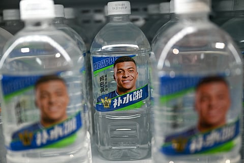 Bottles of Dongpeng Beverage Group's "Bushuila" electrolyte drink featuring French football star Kylian Mbappe on the packaging are displayed at a convenience store in Beijing on October 27, 2026.