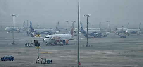 Aircraft are parked at the IGI Airport in New Delhi amid dense fog