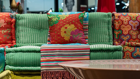 The sofa uses bright colours and eclectic patterns