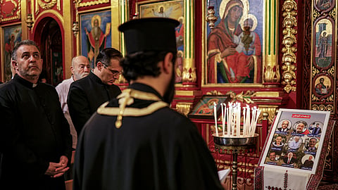 A priest prays during a memorial service at the Greek Orthodox Church of the Transfiguration in the Palestinian city of Ramallah in the Israeli-occupied West Bank, on October 26, 2026, in solidarity with the victims of an attack on the Church of St George in Jordan's village of Hammoud on October 23.