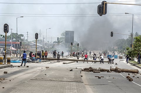 Protesters use different materials to build barricades and block a road as clashes erupt in Dar es Salaam on October 29, 2025, during Tanzania’s presidential elections.
