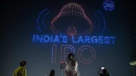 Residents watch a drone show organised by Jio in Mumbai following its initial public offering success