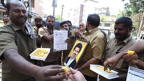 Auto drivers celebrate the state government's revision of autorickshaw meter fares by sharing sweets at TADABAD in Coimbatore on Wednesday.