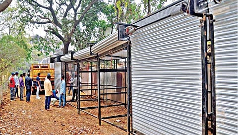 सांगली : कॉलेज कॉर्नरसमोर पेट्रोलपंपामागील रस्त्यावर उभारलेली नवीन लोखंडी खोकी जप्त करून नेताना महापालिकेचे अधिकारी, कर्मचारी.