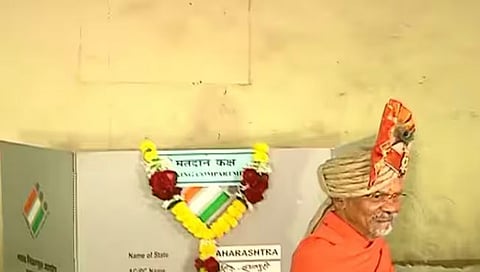 नाशिक : मतदान केल्यानंतर शांतिगिरी महाराजाने आपल्या गळ्यातील ईव्हीएम मशीनला घातला.