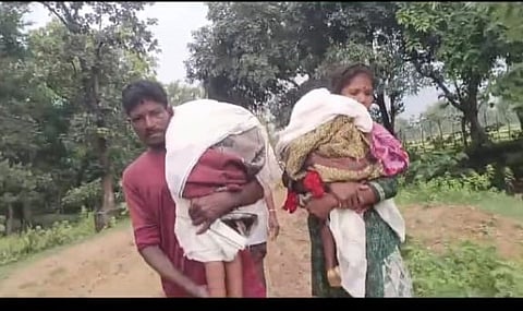 Parents carrying the bodies of both children on their shoulders