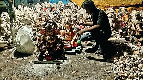 नाशिक : पीओपीच्या मूर्तींवरील बंदी हटवल्याने रात्री बल्बच्या उजेडात काम करताना मूर्तिकार.