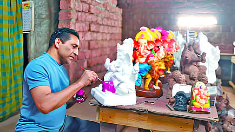 गणेशमूर्तीच्या रंगकामात गुंतलेले आमदार गोविंद गावडे.