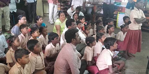 மாணவ மாணவிகளுடன் தரையில் அமர்ந்து பாடம் கேட்ட கலெக்டர்