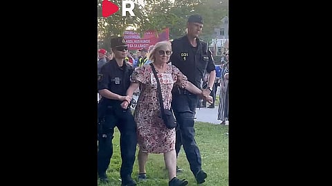 En aktivist förs bort av polis efter att ha stört Magdalena Anderssons tal i Almedalen.