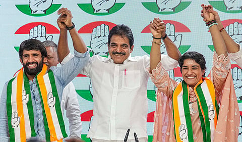AICC General Secretary KC Venugopal with wrestlers Vinesh Phogat and Bajrang Punia as they joined Congress at the party headquarters