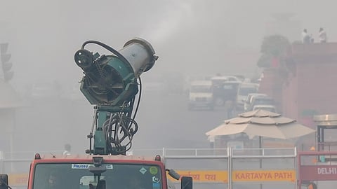 An anti-smog gun sprays mist to mitigate smoggy conditions, in New Delh
