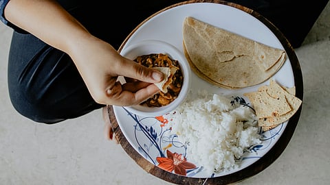 Person Eating Indian food rice and chappati