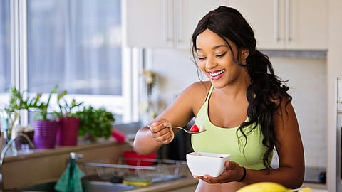 A lady eating fruits