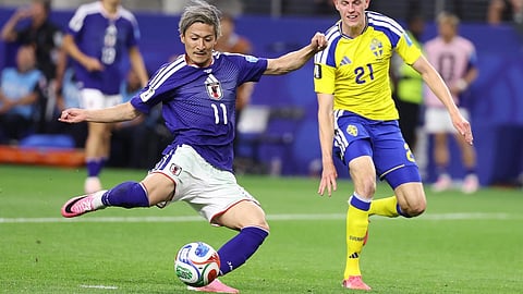 Japan's Daizen Maeda (11) scores his team's first goal as Sweden's Alexander Bernhardsson (21) watches during the World Cup Group F soccer match between Japan and Sweden