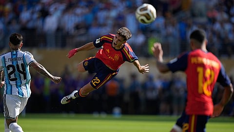 Spain's Pau Cubarsi (22) leaps in the air after he is fouled by Argentina's Enzo Fernandez (24) during the World Cup final soccer match between Spain and Argentina