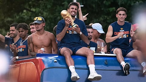 Players from Spain's national soccer team celebrate atop a bus as it travels through crowded streets in Madrid on Monday, July 20, 2026, after Spain defeated Argentina