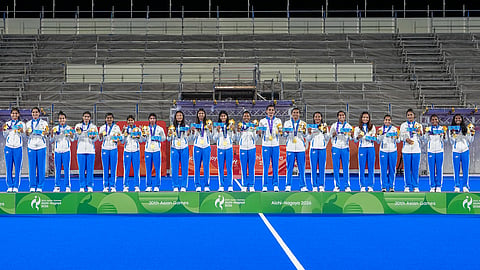 Indias players pose for photographs on the podium after winning gold medal in the womens final Hockey match as they defeat China in Asian Games