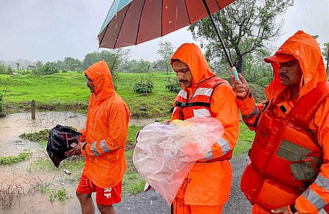 രക്ഷാപ്രവര്ത്തനത്തിനിടെ കുഞ്ഞിനെ പുറത്തെത്തിച്ച ദുരന്തനിവരാണ സേന അംഗങ്ങള്/ പിടിഐ