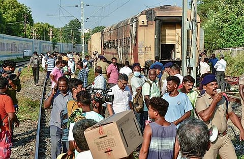 മധുരയില് തീപിടിത്തമുണ്ടായ ട്രെയിന് കോച്ചിനു സമീപം യാത്രക്കാരും സുരക്ഷാ ഉദ്യോഗസ്ഥരും/പിടിഐ