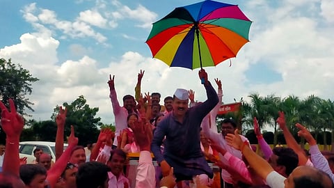 A teacher cheering with an umbrella