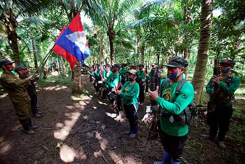 In this photo taken Nov. 23, 2016, members of the New People's Army communist rebels with face painted to conceal their identities, stand in formation during ceremonies before a news conference held at their guerrilla encampment tucked in the harsh wilderness.