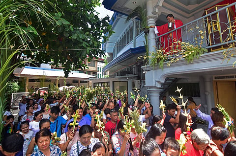 PALM SUNDAY. Hundreds of churchgoers raise their palm as Fr. Voltaire Dimol splashes holy water during the observance of Palm Sunday at the San Pedro Cathedral in Davao City in 2019.