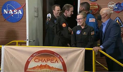 In this image made from video provided by NASA, the crew members of the first CHAPEA mission, Kelly Haston, third right, Ross Brockwell, center, Nathan Jones, left, and Anca Selariu, not in photo, emerge from their craft, Saturday, July 6, 2024, at Johnson Space Center in Houston, Texas. The four volunteers crew members spent more than 12 months inside NASA's first simulated Mars environment at Johnson Space Center in Houston, coming out of the artificial alien environment Saturday.