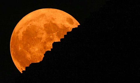 The supermoon rises behind the historical site of Giza Pyramids, near Cairo, Egypt, Monday, Aug. 19, 2024.