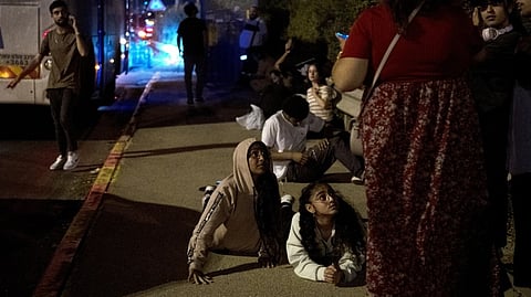 Israelis wait to re-board their bus after projectiles were launched from Iran are being intercepted in the skies over in Rosh HaAyin, Israel, Tuesday, Oct. 1, 2024. /