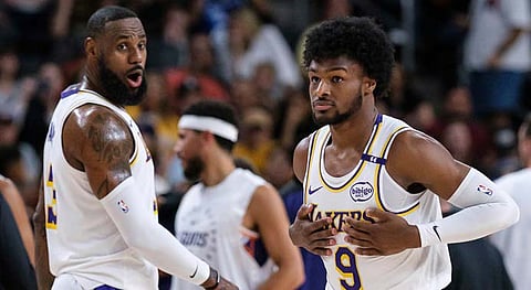 Los Angeles Lakers guard Bronny James (9), right, steps onto the court with Los Angeles Lakers forward LeBron James (23) during the first half of a preseason NBA basketball game Sunday, Oct. 6, 2024, in Palm Desert, California.
