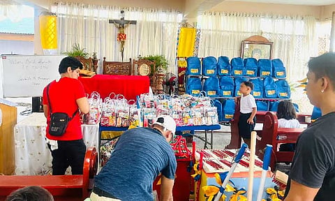 BLESSINGS TO STUDENTS
Students of San Nicolas Elementary School in Masantol town receive assistance from private groups on the first day of classes. With several classrooms flooded due to rain and high tide level, classes are temporarily being held at the nearby San Nicolas Chapel. - Photo by John Kristoffer Yabut