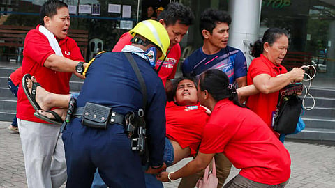 PEOPLE at the Cebu City Palace of Justice in the Qimonda IT Center building rush to help a woman who fainted during an evacuation following an earthquake on Thursday, Oct. 10, 2025. The Qimonda building, which temporarily houses courts under the Cebu City Hall of Justice, at the North Reclamation Area had already sustained wall cracks from the Sept. 30 tremor that devastated parts of northern Cebu. / ZHAN FRANCISCO RAMIREZ, SUNSTAR CEBU JUNIOR JOURNO