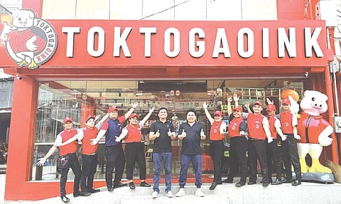 FOODPRENEURS. Toktogaoink founders Ronald Bhen Madolin and Abraxas Tago stand with their growing team at the brand’s Cebu City branch — one of the food ventures they built after turning their online mukbang popularity into a full-fledged business. /