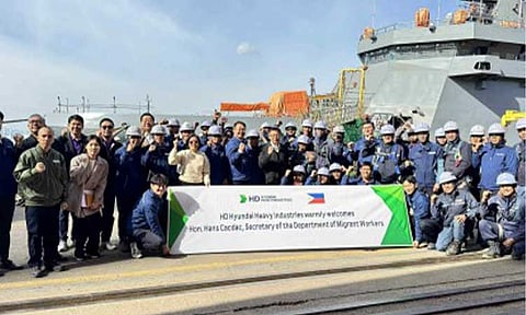 WAGE HIKE. Migrant Workers Secretary Hans Leo Cacdac (center) poses with the Filipino workers of Hyundai Heavy Industries in Ulsan, South Korea in this photo taken on Oct. 30, 2025. The Department of Migrant Workers (DMW) said Friday (Feb. 6, 2026) that more than 25,000 OFWs in South Korea will benefit from the 2026 minimum wage increase to 10,320 Korean Won per hour, which took effect on Jan. 1 and covers all industries. (Photo courtesy of DMW)