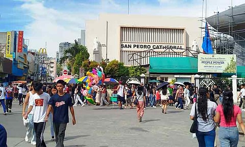 Crowds are filling San Pedro Street, with churchgoers visiting the nearby San Pedro Cathedral and others exploring the newly painted Davao City Hall.