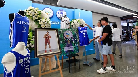Basketball jerseys and a framed portrait of Rene Clert “Bobet” Baterbonia in his team uniform are displayed at the Ateneo de Davao Senior High School–Bangkal Campus as supporters gather at Christ the King Chapel to pay their final respects on Friday evening, June 12, 2026.