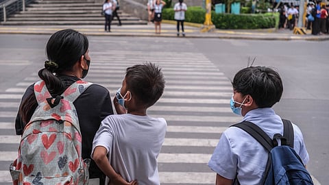 Students are picked up by their parents from school while pedestrians wear face masks in Cebu City on Thursday, July 9, 2026, after Cebu City Mayor Nestor Archival ordered the suspension of classes at all levels in both public and private schools until further notice following the volcanic ashfall from the recent eruption of Kanlaon Volcano. (Juan Carlo de Vela)