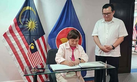 Tagum City Tourism, Arts, and Culture Council Chairperson Alma L. Uy signs the logbook at the Malaysian Consulate General in Davao during the Tagum delegation’s visit on Aug. 3, 2026. Uy and representatives of the Tagum City Durian Growers Association met with Malaysian Consul General Deddy Faisal Ahmad Salleh, right, to discuss a proposed agricultural technology and technical exchange program aimed at improving local durian growers’ knowledge, farming techniques, and industry practices.
