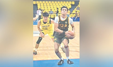 JAGUAR DRIVE. University of San Jose-Recoletos Jaguars guard Christian Carl Sollano (right) drives past a University of Cebu-Lapulapu and Mandaue Webmasters defender for a layup during their Cesafi Season 26 game at the New Cebu Coliseum. The Jaguars crushed the Webmasters, 75-46, to give rookie coach Roger Yap his first win. / JUN B. MIGALLEN