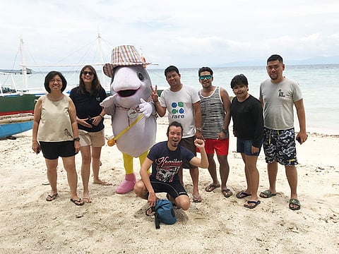 FRIENDS. The team from Rare Philippine with the writers and artist with Badian town's mascot Toy Ando (short for Anduhaw, the local name for mackerel). Rare Phils use mascots to popularize issues and concerns. From left are Yasmin D. Arquiza, Rare Senior Manager, Communications and Events; Mitzi Borromeo of CNN Phils.; Roquelito Mancao, Director for Technical Operations of Rare Philippines; freelance writer and blogger Ferz Decena; the writer; Rare Office Management and Program Coordinator Francis Tiu, and; cartoonist Manix Abrear (in front). (Stella A. Estremera)