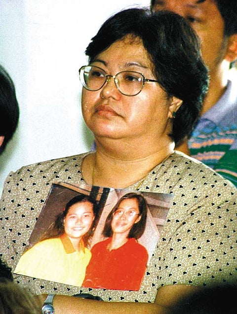 CEBU. Thelma Chiong holds photos of her daughters Jacqueline and Marijoy. The sisters were abducted, raped and murdered. Only Marijoy's body was found. (SunStar File Photo)