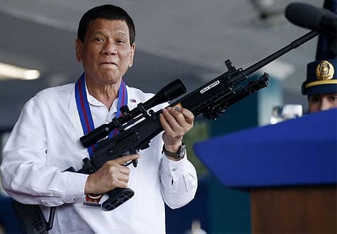 MANILA. In this April 19, 2018, file photo, Philippine President Rodrigo Duterte jokes to photographers as he holds an Israeli-made Galil rifle at Camp Crame in Quezon City. (AP)