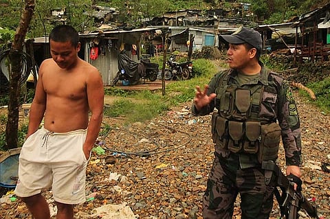 BENGUET. In Itogon, police try to convince a miner in Tuding to evacuate his shanty as Typhoon Rosita approached Benguet. The Department of Environment and Natural Resources (DENR) has enforced an order to stop all illegal mining activities in the Cordilleras. (Photo by Jean Nicole Cortes)