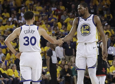 Golden State Warriors guard Stephen Curry (30) reacts with forward Kevin Durant (35) during the first half of Game 1 of a second-round NBA basketball playoff series against the Houston Rockets in Oakland, Calif., Sunday, April 28, 2019. (AP Photo)