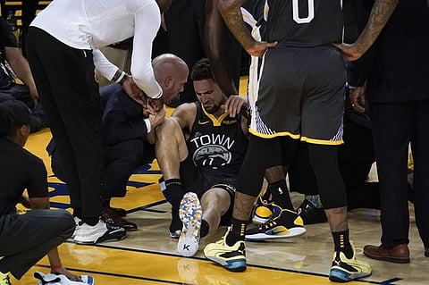 Golden State Warriors guard Klay Thompson, center, is helped up after being injured during the second half of Game 6 of basketball's NBA Finals against the Toronto Raptors in Oakland, Calif., Thursday, June 13, 2019. (AP)