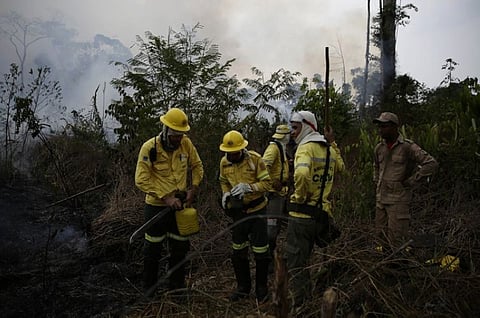 Firefighters rest briefly as they put out fires along the road to Jacunda National Forest, near the city of Porto Velho in the Vila Nova Samuel region which is part of Brazil's Amazon, Monday, August 26, 2019. The Group of Seven nations on Monday pledged tens of millions of dollars to help Amazon countries fight raging wildfires, even as Brazilian President Jair Bolsonaro accused rich countries of treating the region like a "colony." (AP)