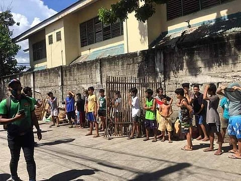 TISA TROUBLE. Members of Task Force Kasaligan (in green shirts) line up quarantine violators, adults and minors, in Barangay Tisa, Cebu City on Thursday afternoon, Oct. 1, 2020. The violators include eight children, who played games inside an internet cafe without masks and they also failed to observe social distancing. / Contributed, Cebu City Police Office