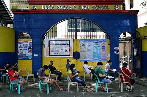 MANILA. People wearing masks and face shields wait for their turn to pick up student electronic tablets as online classes are scheduled to start next week in the Dona Rosario High School in Quezon City, Philippines, Thursday, October 1, 2020. (AP)